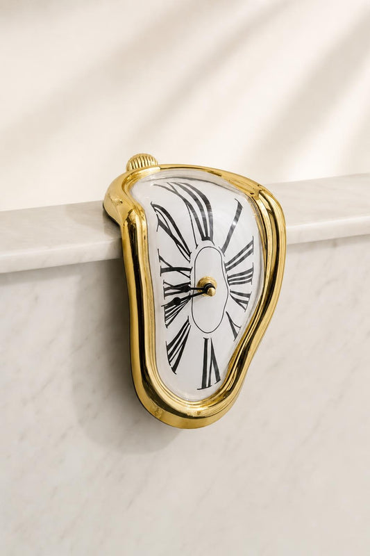 Reloj surrealista derretido, acabado oro, sobre el borde de una consola de mármol